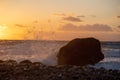 Sea Ã¢â¬â¹Ã¢â¬â¹wave at sunset hitting rock on the beach